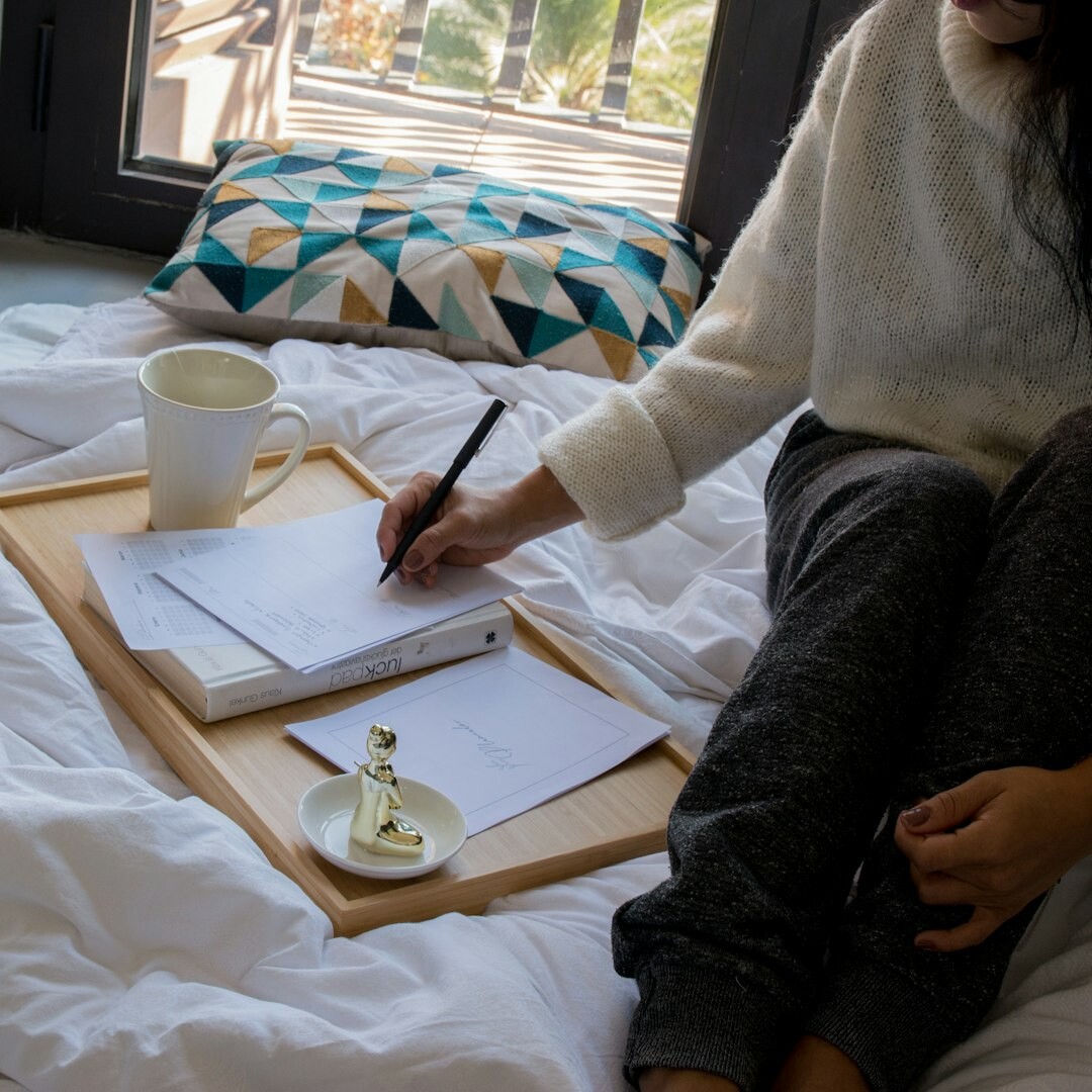 Turkish woman writing on a storyboard notepad with a laptop open