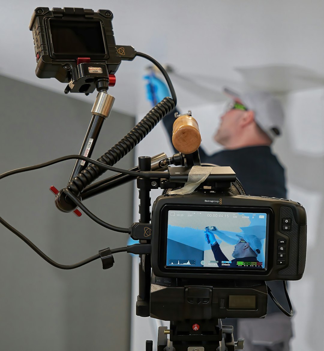 Turkish man editing a video timeline on a large monitor with color panels