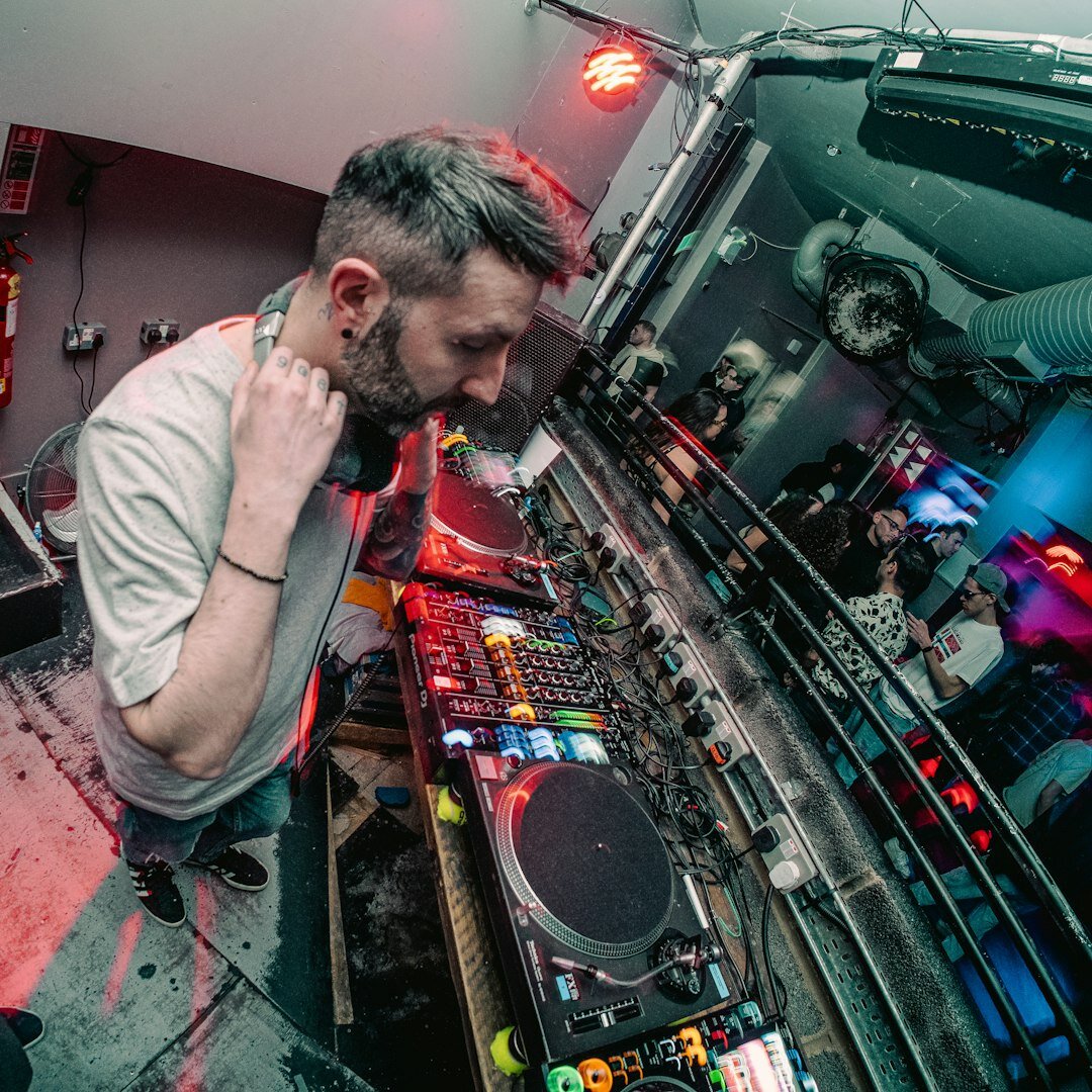 Turkish man wearing headphones in front of an audio mixing console